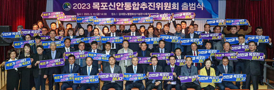 2023 목포신안통합추진위원회 출범식으로 일시 : 2023. 3. 10.(금) 14:00 장소 : 김대중노벨평화상기념관 다목적실에서 행사가 진행되고 있는 다목적실에서 관계자들이 신안과 목포는 하나다라는 손피켓을 들고 기념촬영을 하고 있는 모습 