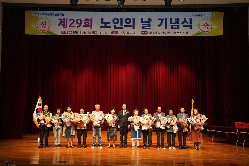 노인의 날 기념식에서 수상자들이 꽃다발을 들고 관계자와 함께 단체 기념 촬영을 하고 있는 모습이다.